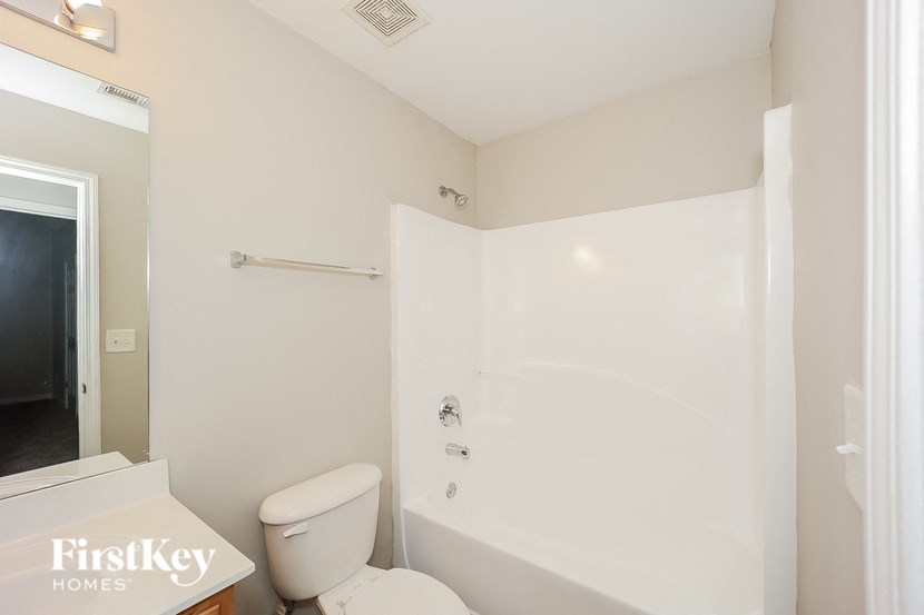 a bathroom with a toilet and a tub and a sink