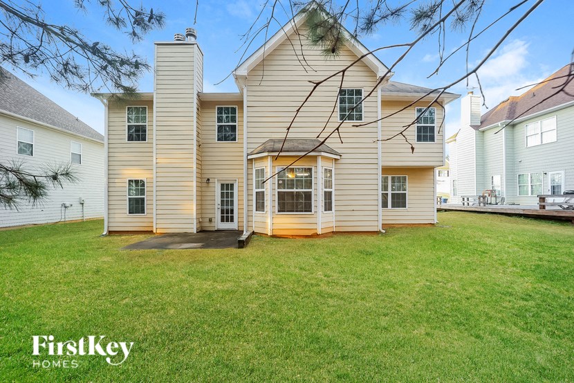 a white house with white siding and a green lawn