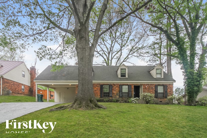 A house with a large tree in front of it.