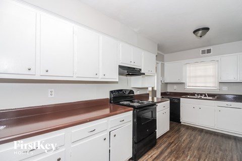 a kitchen with white cabinets and black appliances