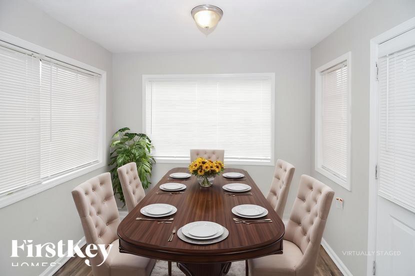 A dining room with a wooden table set for six.
