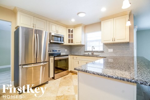 a kitchen with white cabinets and stainless steel appliances and granite counter tops