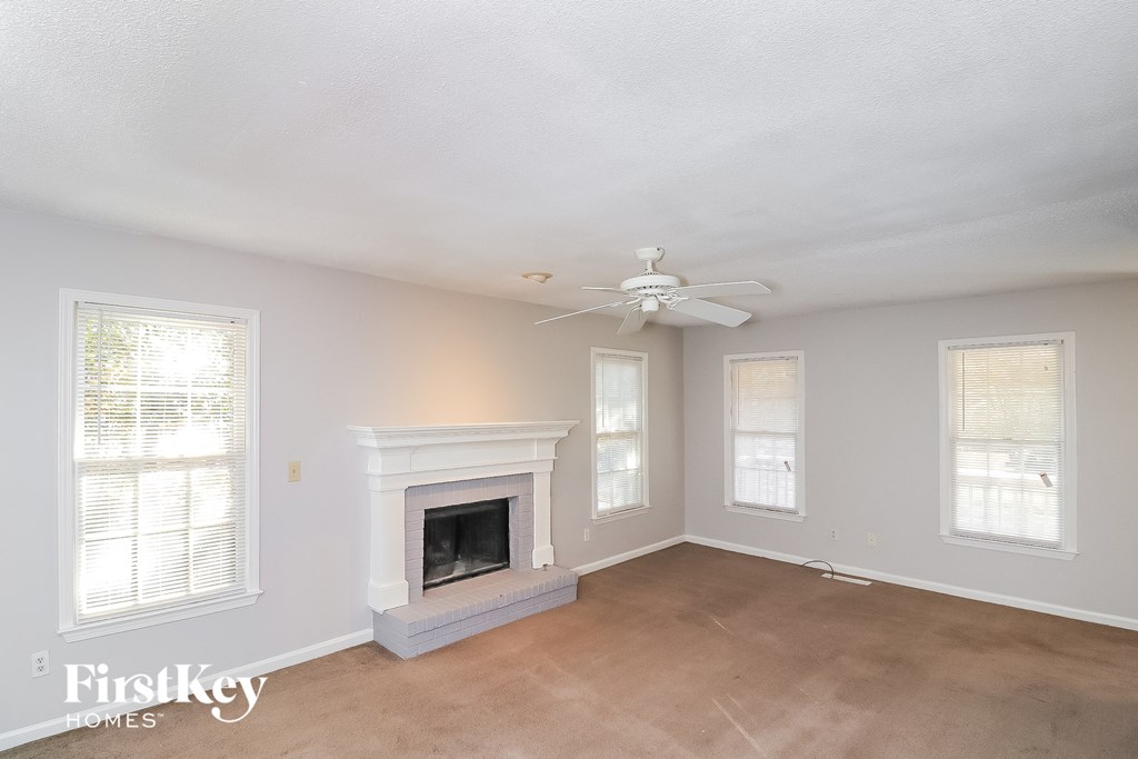 a living room with a fireplace and a ceiling fan