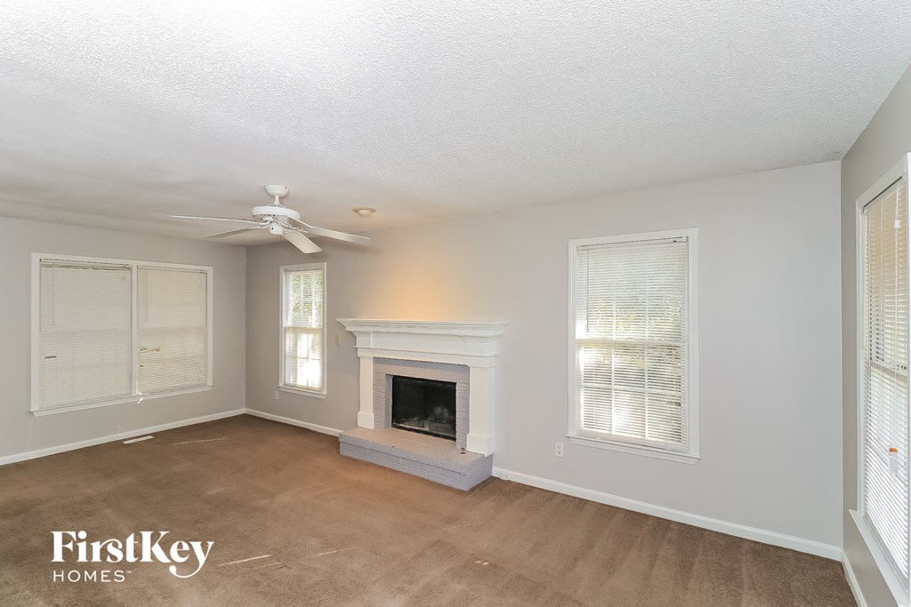 a living room with a fireplace and a ceiling fan