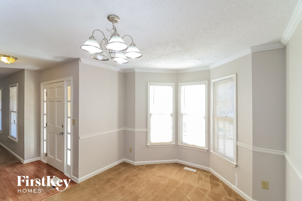 a dining room with three windows and a chandelier
