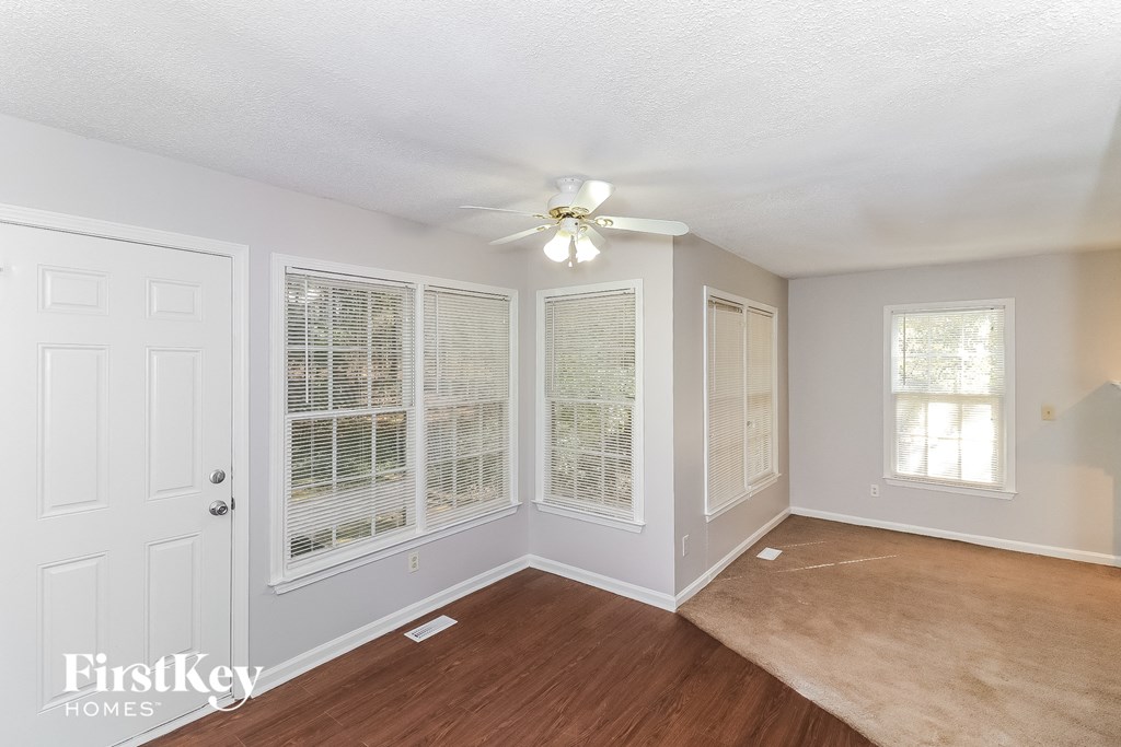 a living room with a large window and a ceiling fan