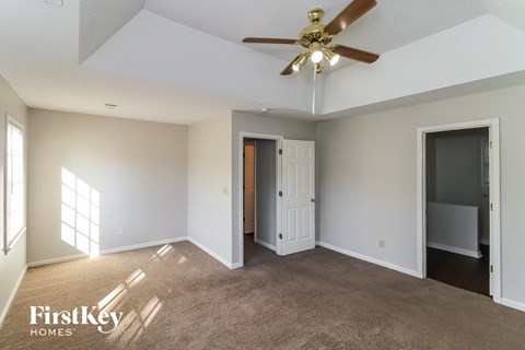 a living room with carpet and a ceiling fan