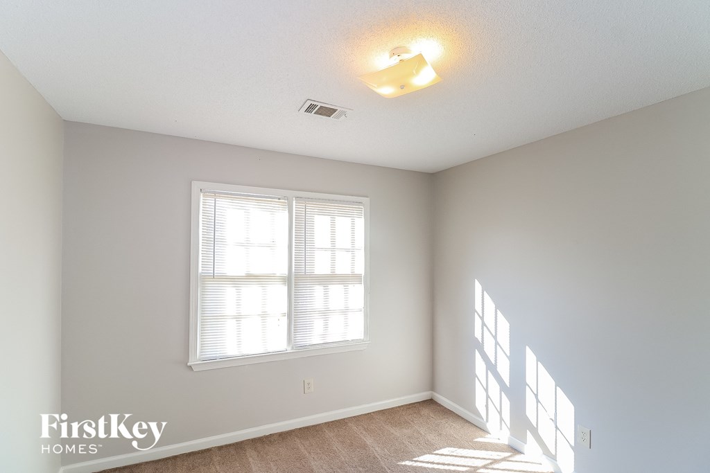 a bedroom with a large window and a ceiling fan