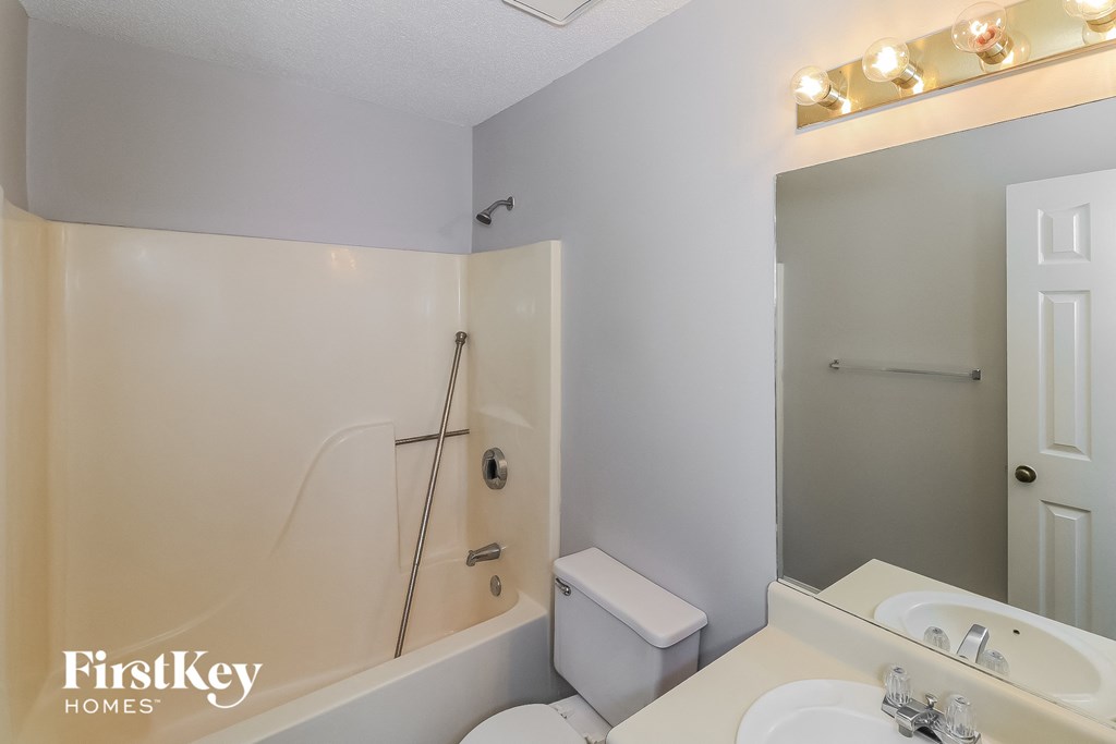 a bathroom with a shower toilet and sink and a mirror