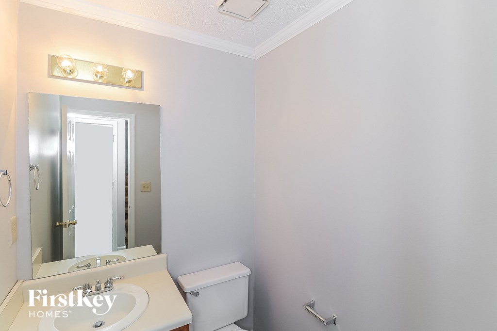 a small bathroom with a toilet and a sink and a mirror