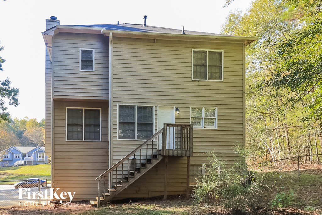 the back of a house with stairs and a deck