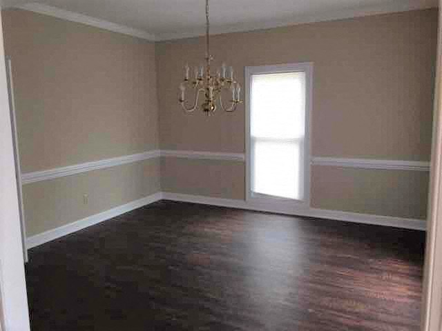 A room with a chandelier and a window.