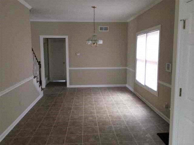 A room with a tiled floor and a chandelier hanging from the ceiling.