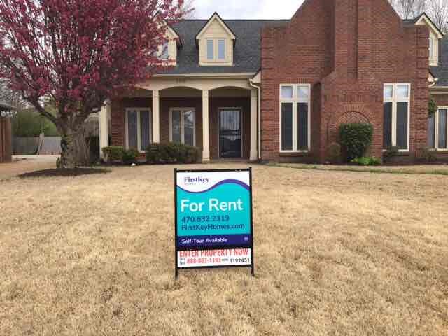A house with a sign in front that says For Rent.