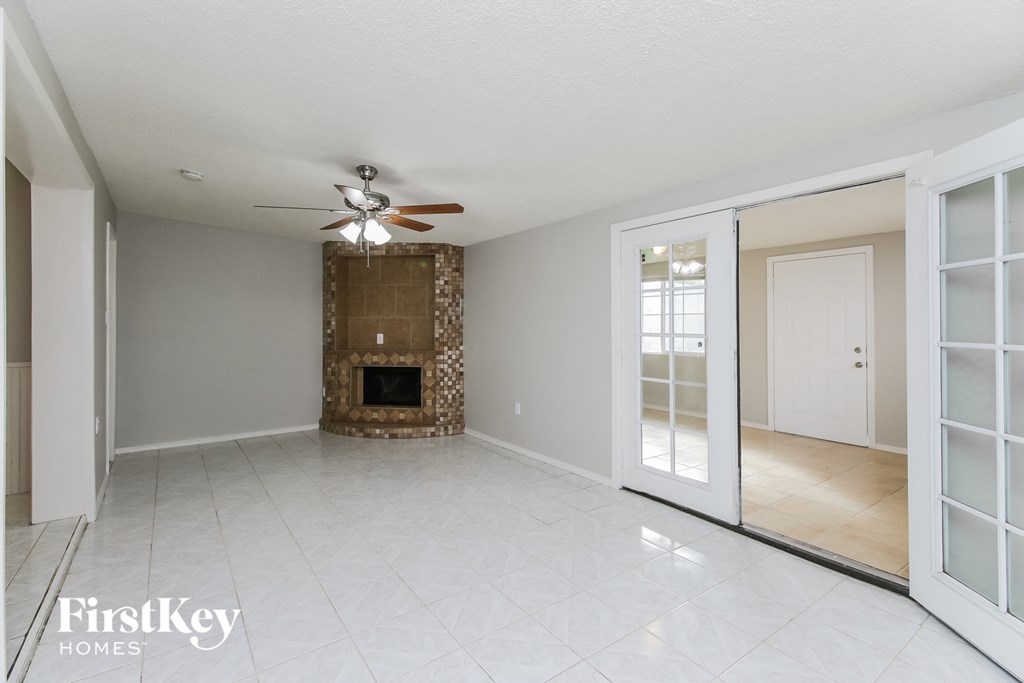 a living room with a fireplace and a ceiling fan