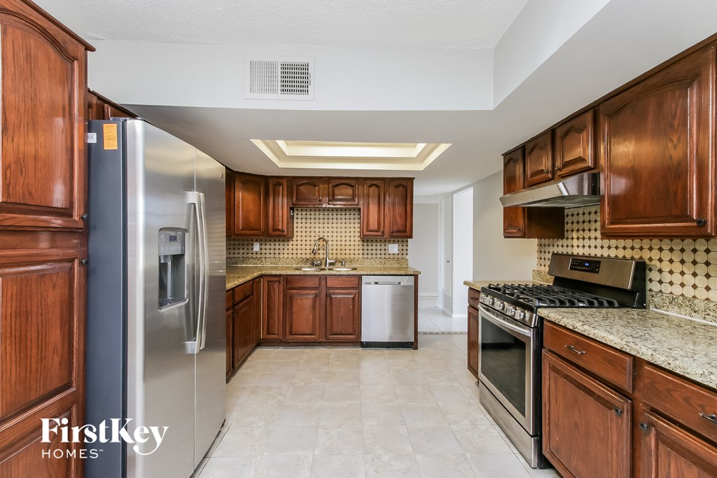 a kitchen with wooden cabinets and stainless steel appliances