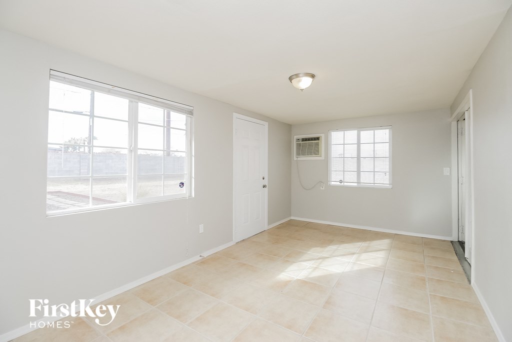an empty living room with a door and a window