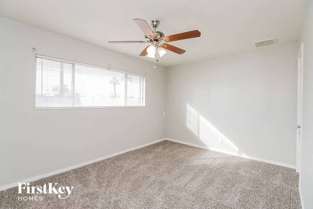 a living room with a ceiling fan and a window