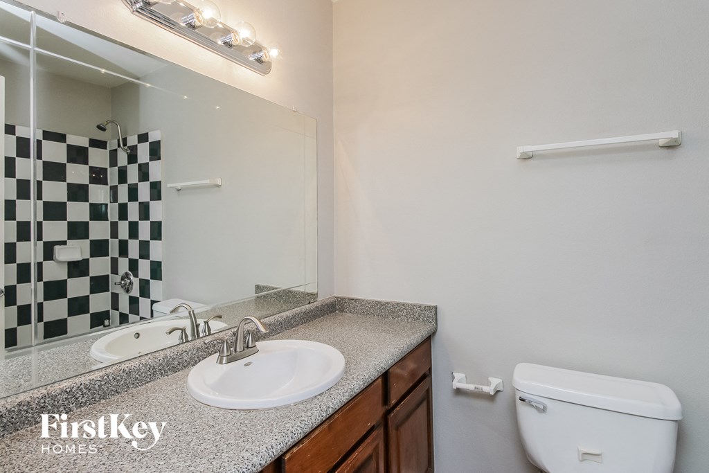 a bathroom with a sink toilet and a mirror