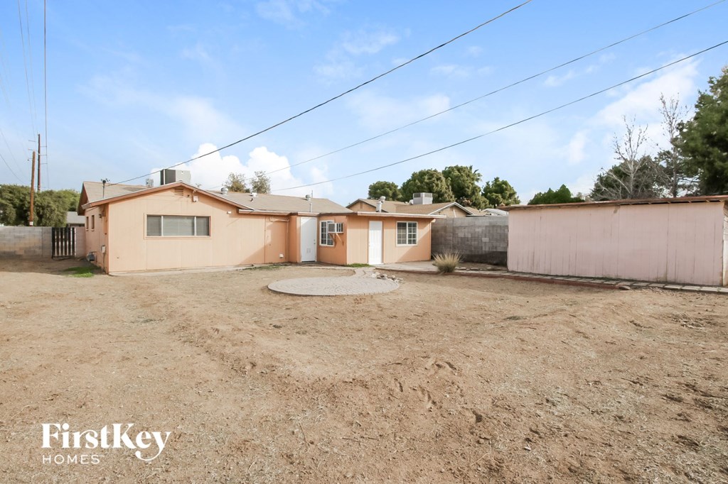a home with a dirt lot and a house next to it