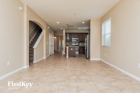 A spacious kitchen with a refrigerator, oven, and cabinets is visible in the image.