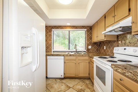 a kitchen with white appliances and wooden cabinets