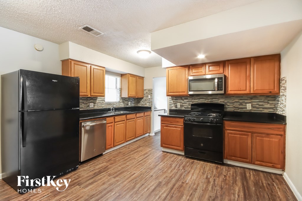 A kitchen with wooden cabinets and black appliances.