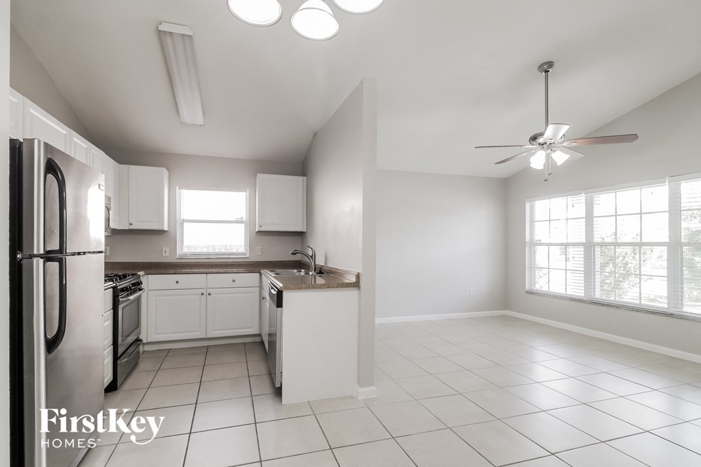 A kitchen with white cabinets and appliances is on the market.