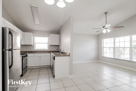 A kitchen with white cabinets and appliances is on the market.