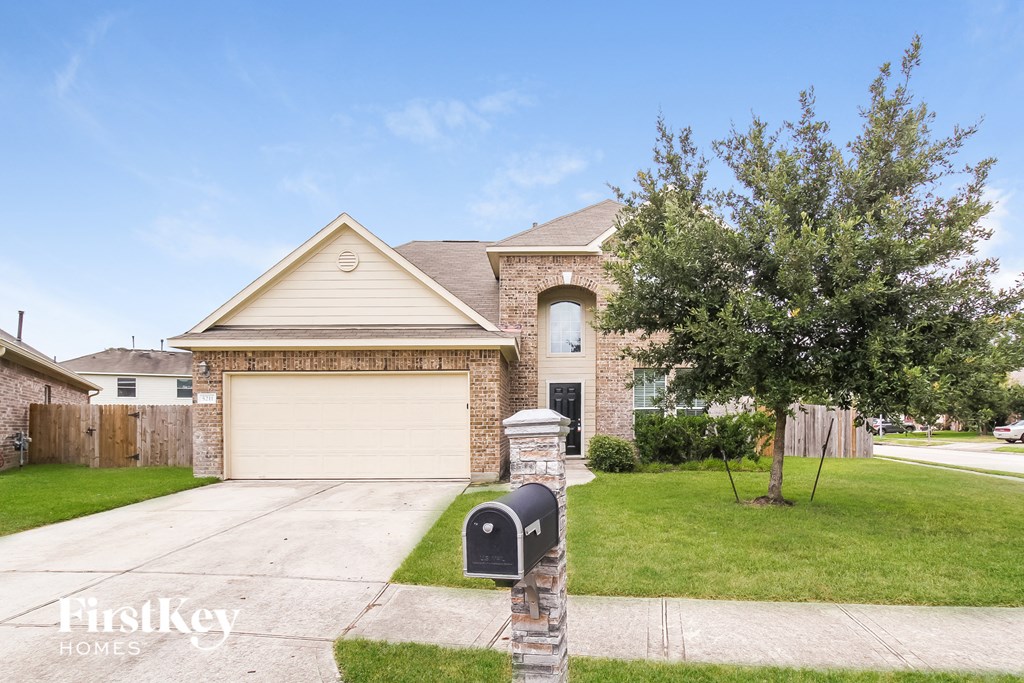 A house with a garage and a mailbox in front of it.