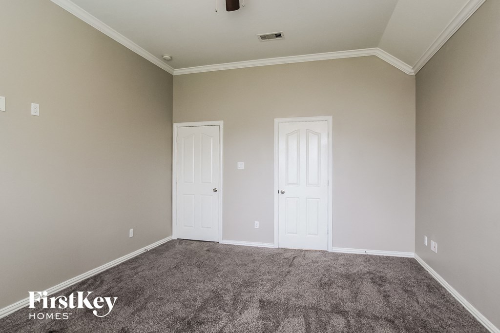 A room with two white doors and a carpeted floor.