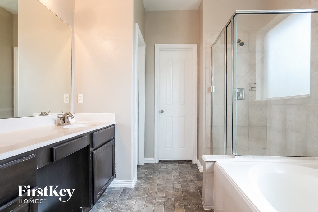 A bathroom with a tub, sink, and shower.