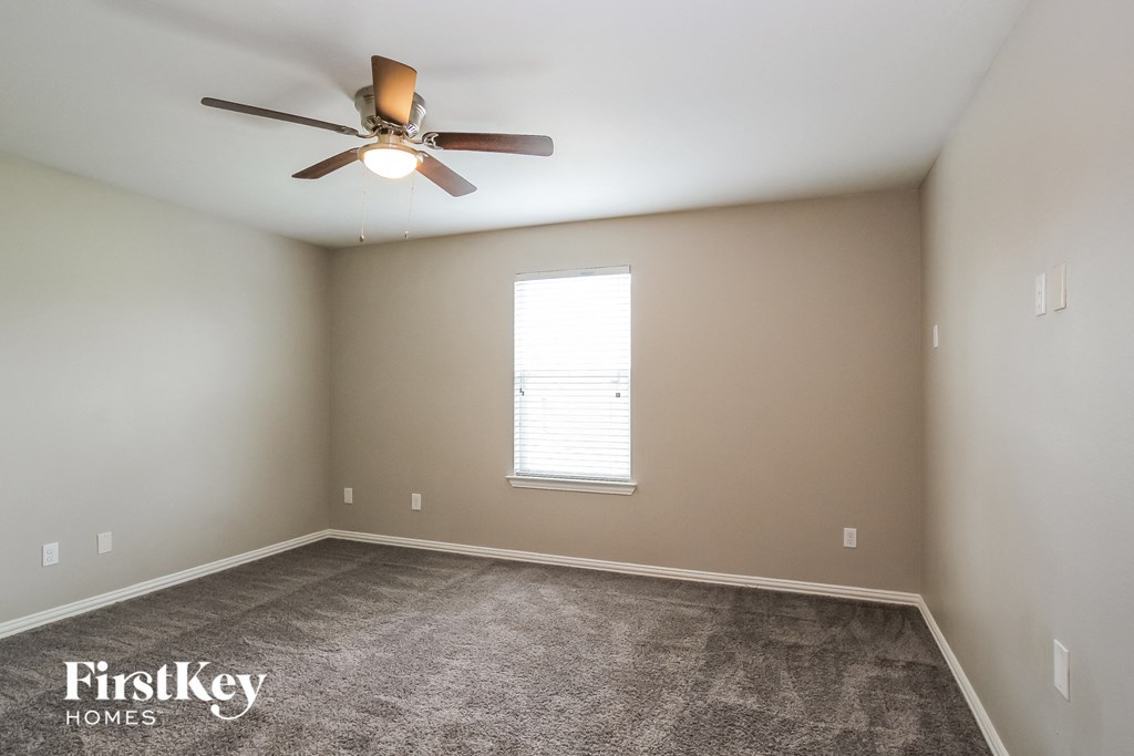 A room with a ceiling fan and a window.