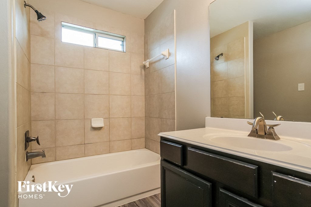 A bathroom with a white tub and sink.