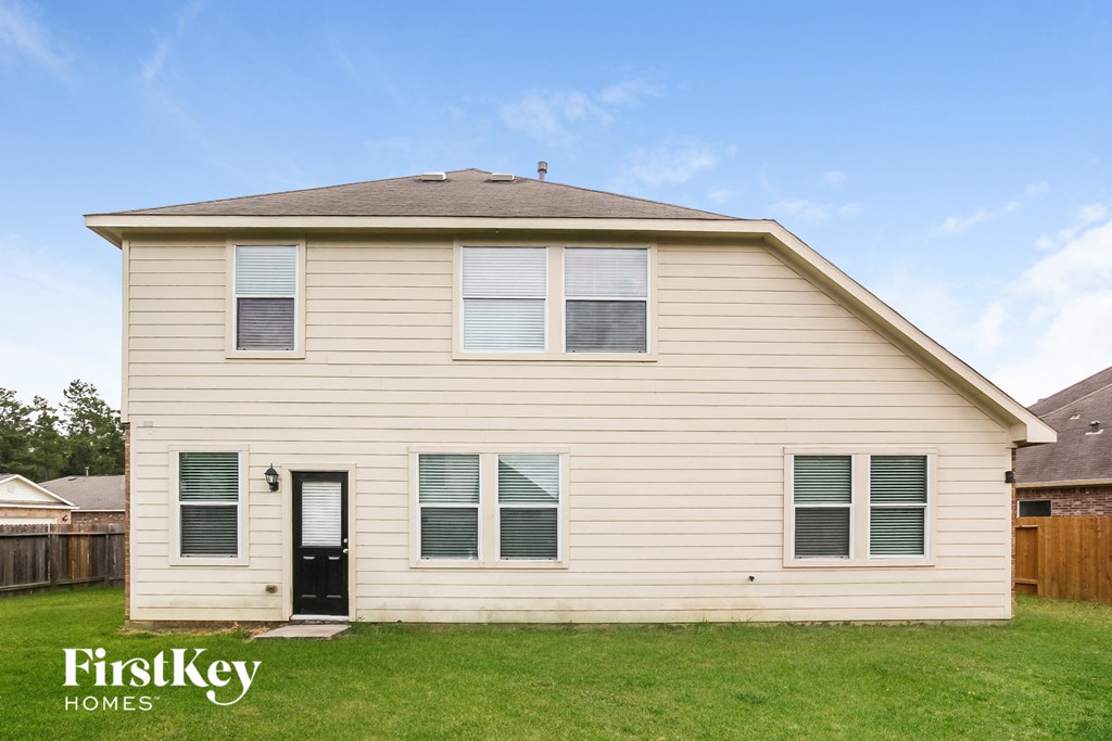 A two-story house with a black front door and a brown roof.