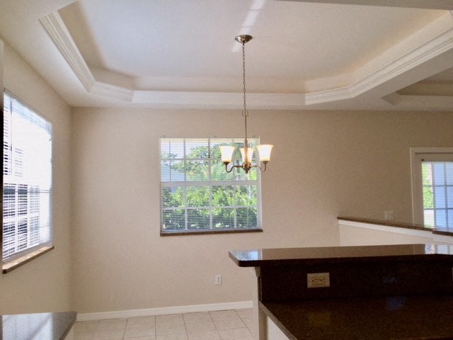 A room with a brown counter and a chandelier.