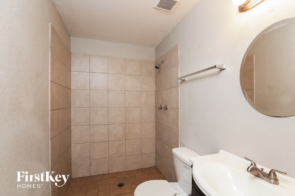 a bathroom with a toilet and a sink and a shower