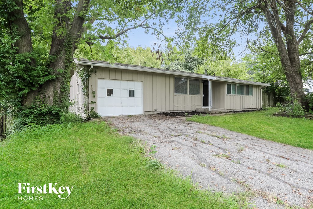 a white house with a white garage and some trees