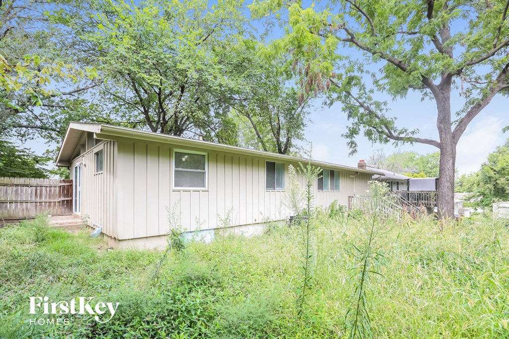a home in a field with tall grass and trees