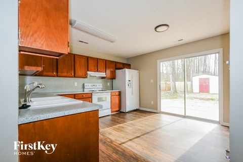A kitchen with wooden cabinets and a white sink.