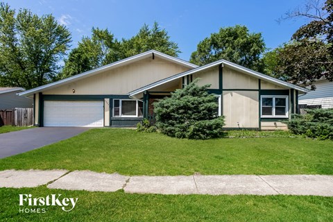 a home with a lawn and a sidewalk in front of it