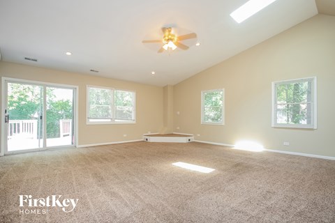 an empty living room with a ceiling fan