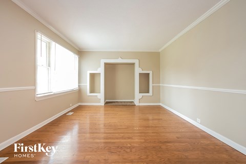 an empty living room with wood floors and white walls