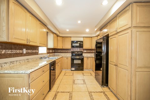 a large kitchen with wood cabinets and black appliances