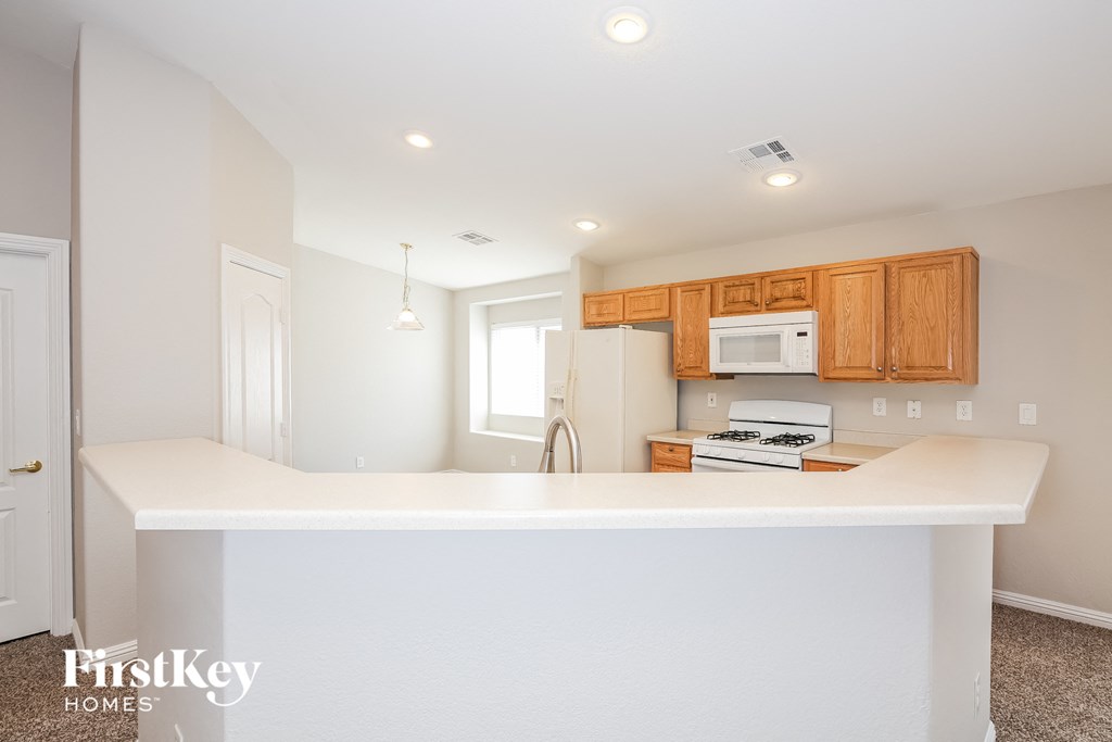 a kitchen with a white counter top and a refrigerator