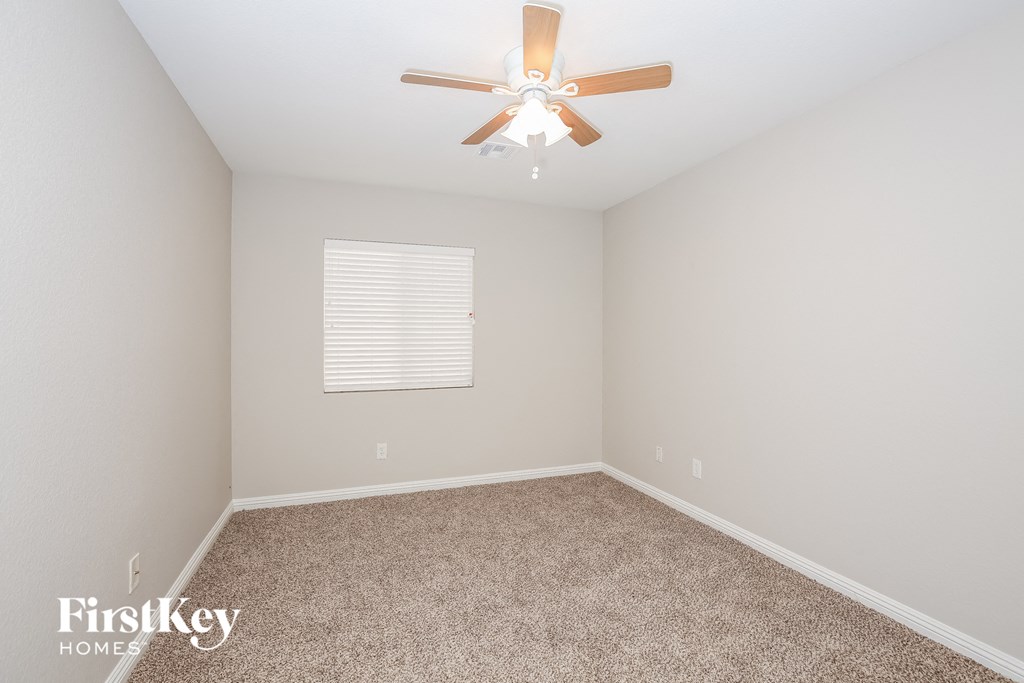 a bedroom with carpet and a ceiling fan