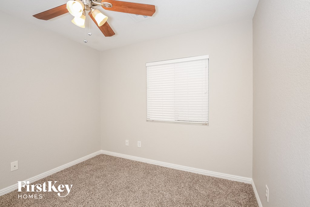 the upstairs bedroom has a ceiling fan and a window