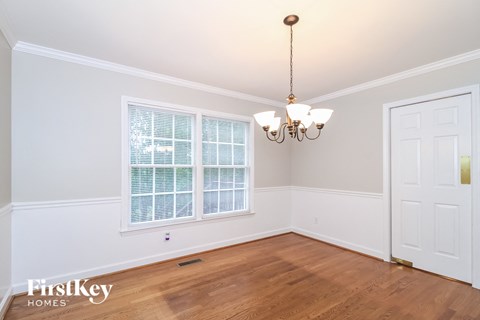a dining room with a large window and a chandelier