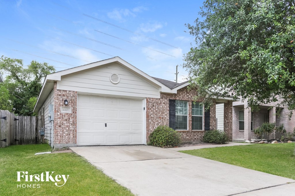 a small brick house with a white garage door