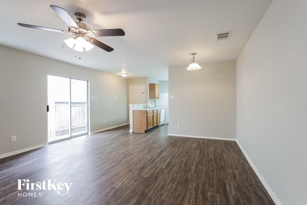 a living room with wood flooring and a ceiling fan